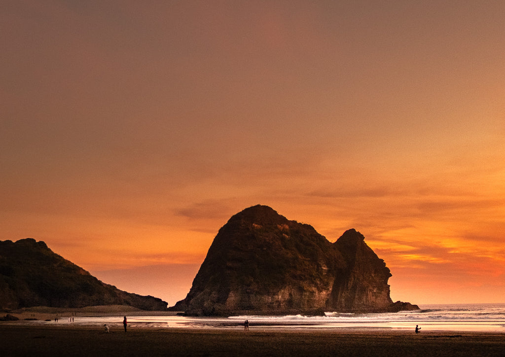 Sunset over a beach with large rock formations